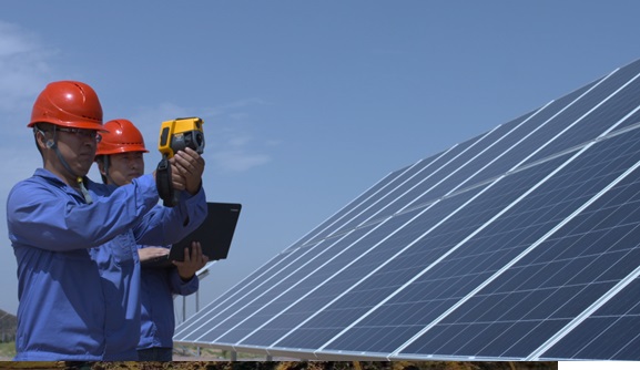 Two men in front of a solar field